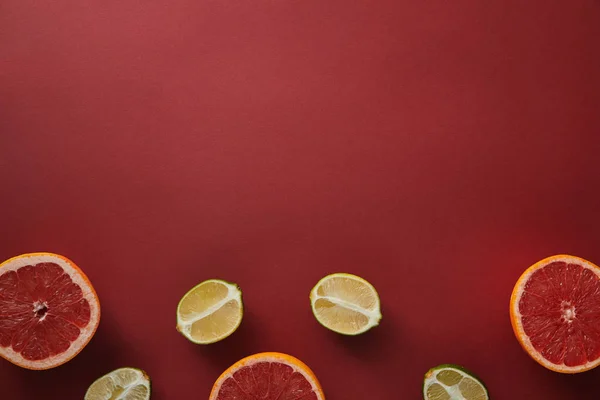 Vista superior de toranjas e limas na superfície vermelha — Fotografia de Stock
