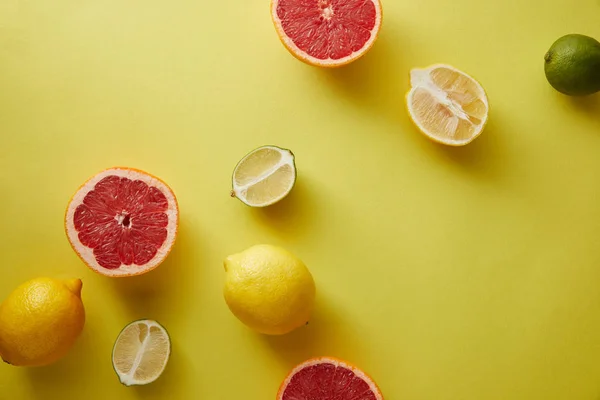 Draufsicht auf Grapefruits, Zitronen und Limetten auf gelber Oberfläche — Stockfoto