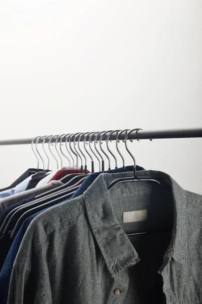 Different shirts on hangers isolated on white — Stock Photo