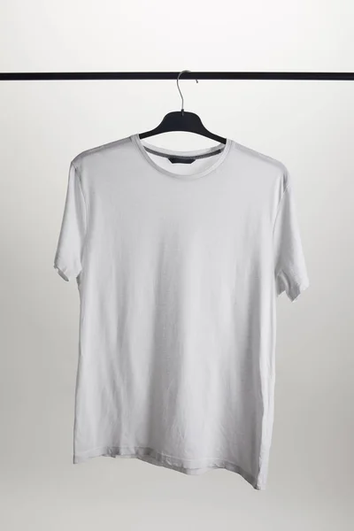 Una camisa blanca en percha aislada en blanco - foto de stock