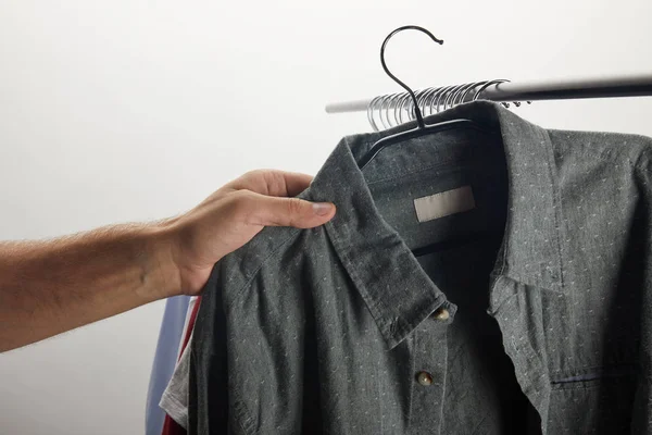 Imagen recortada del hombre tomando camisa gris aislada en blanco - foto de stock