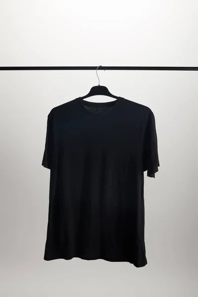 One black shirt on hanger isolated on white — Stock Photo