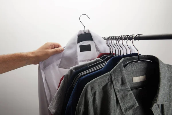 Imagem cortada do homem tomando camisa branca isolada no branco — Fotografia de Stock