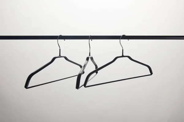 Three empty hangers on stand isolated on white — Stock Photo