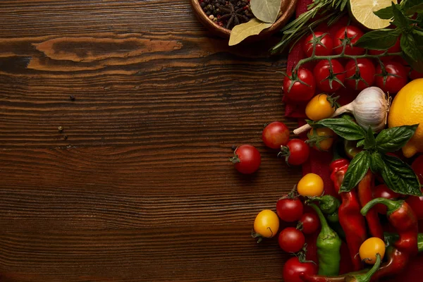 Vista superior de verduras frescas maduras y especias en la superficie de madera - foto de stock