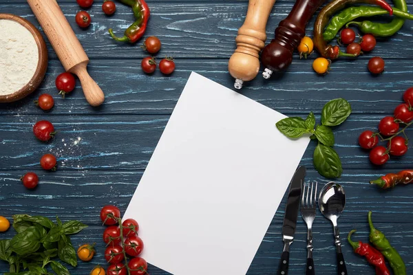 Vista superior de la plantilla de menú en blanco, verduras frescas, cubiertos y especias en la superficie de madera - foto de stock