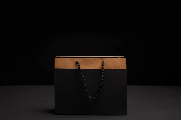 Крупный план бумажной сумки на черном рюкзаке — стоковое фото