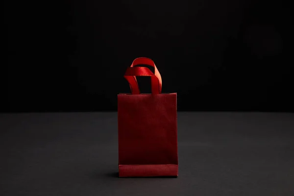 Vue rapprochée du sac à provisions en papier rouge sur fond noir — Photo de stock