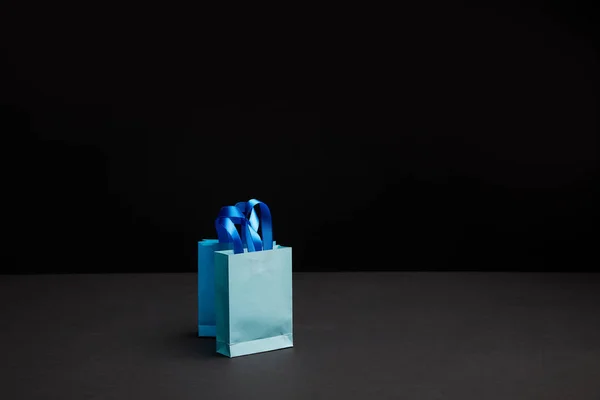 Close up view of blue shopping bags on black backdrop — Stock Photo