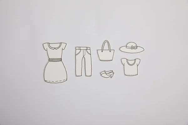 Верхний вид разложенной бумажной одежды, изолированной на сером, торговый концепт — стоковое фото