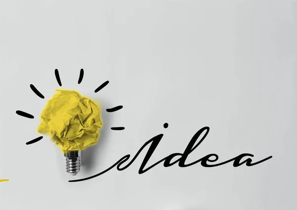 Top view of crumpled paper as light bulb with idea lettering — Stock Photo