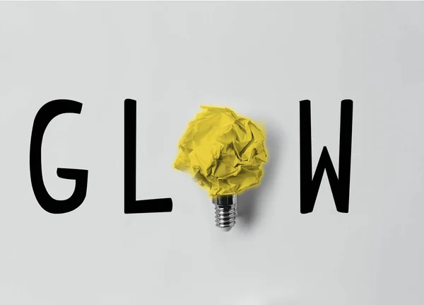 Top view of crumpled paper as light bulb with glow word — Stock Photo