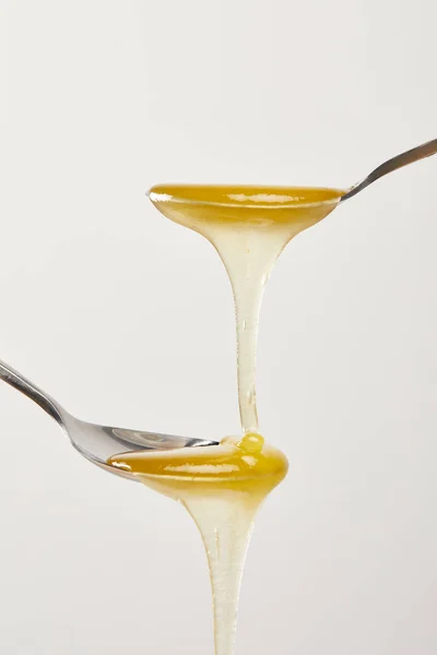 Close up view of spoons with honey on white background — Stock Photo