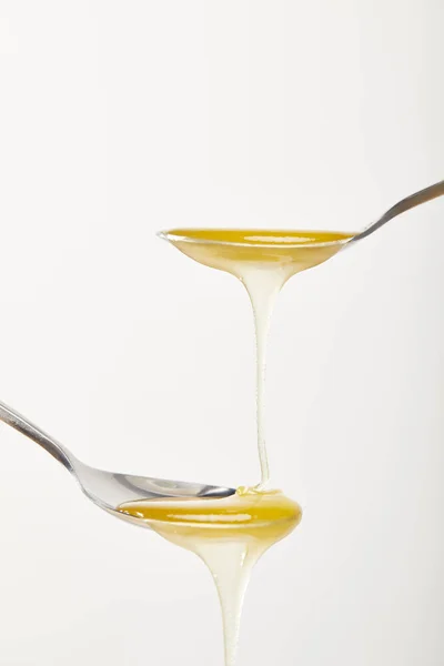 Close up view of spoons with honey on white background — Stock Photo