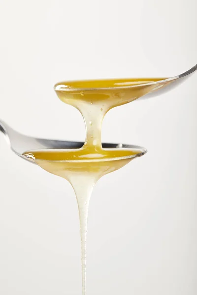 Close up view of spoons with honey on white background — Stock Photo
