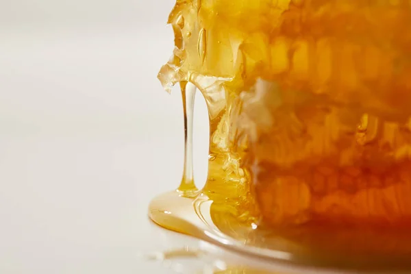Close up vista de cera de abelha doce e mel no fundo branco — Fotografia de Stock