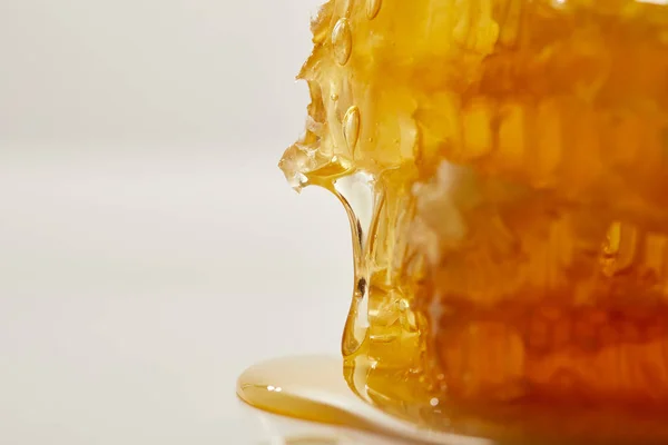 Vista de cerca de la cera de abeja dulce y la miel sobre fondo blanco - foto de stock
