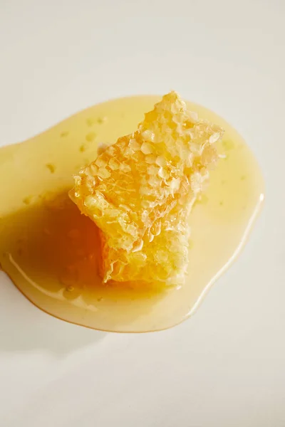 Vista de perto de cera de abelha doce e mel em mesa branca — Fotografia de Stock