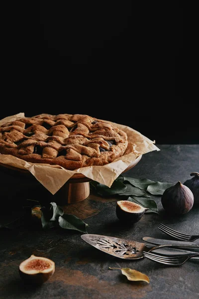 Vue rapprochée de tarte maison sur support de gâteau sur plateau grungy avec fond noir — Photo de stock