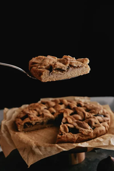 Close up view of piece of homemade pie on cake server on black background — Stock Photo