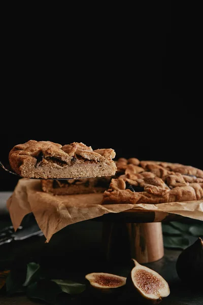 Vue rapprochée du morceau de tarte maison sur le serveur de gâteau sur fond noir — Photo de stock