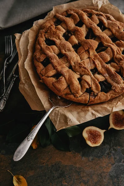 Vue du dessus du serveur de gâteaux et tarte maison sur papier cuisson sur surface grunge — Photo de stock