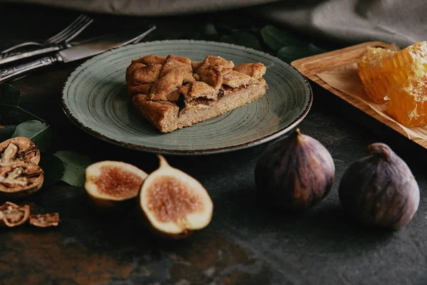 Vue rapprochée de figues fraîches et tarte maison sur plateau grunge foncé — Photo de stock