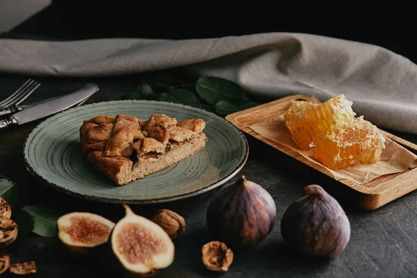Close up view of homemade pie on plate, figs, beeswax and hazelnuts on grungy surface — Stock Photo