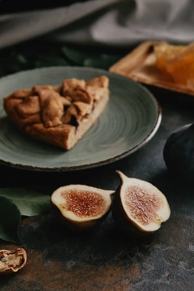 Close up view of fresh fugs and piece of homemade pie on plate on grungy surface — Stock Photo