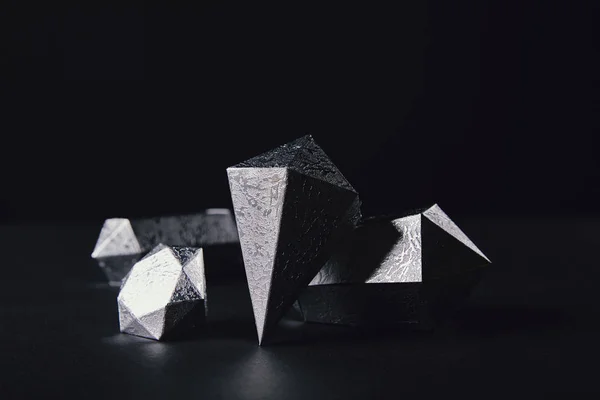Vista de cerca de piezas de plata facetadas brillantes en negro - foto de stock