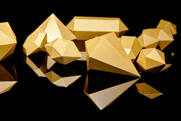 Close-up view of shiny faceted golden nuggets reflected on black — Stock Photo