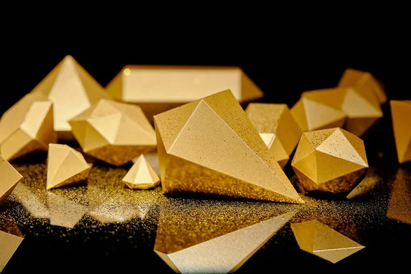Nahaufnahme von glitzernden Goldstücken und goldenem Staub, der sich auf Schwarz reflektiert — Stockfoto