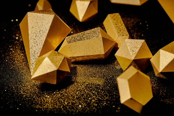 Close-up view of shiny golden pieces and dust on black — Stock Photo