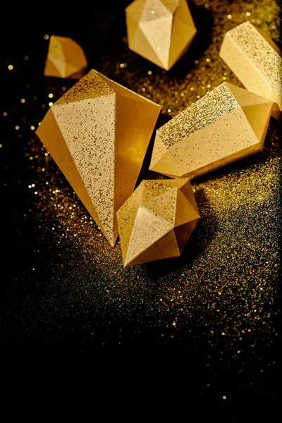 Top view of shiny golden pieces and dust on black — Stock Photo