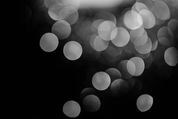 Glowing silver bokeh on black festive background — Stock Photo