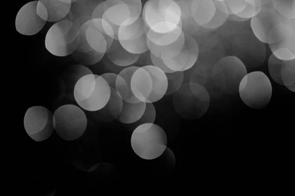 Sparking silver festive bokeh on black background — Stock Photo