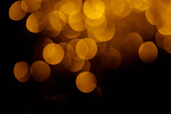 Gold festive bokeh on black background for holiday — Stock Photo