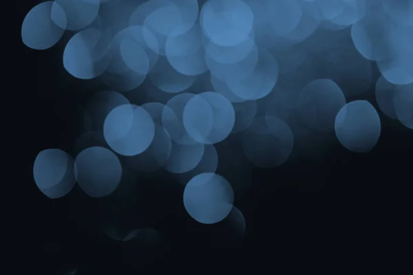 Bokeh festivo azul sobre fondo negro para vacaciones - foto de stock