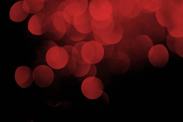 Bokeh festivo vermelho no fundo preto — Fotografia de Stock