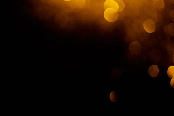 Golden bokeh on black background with copy space — Stock Photo