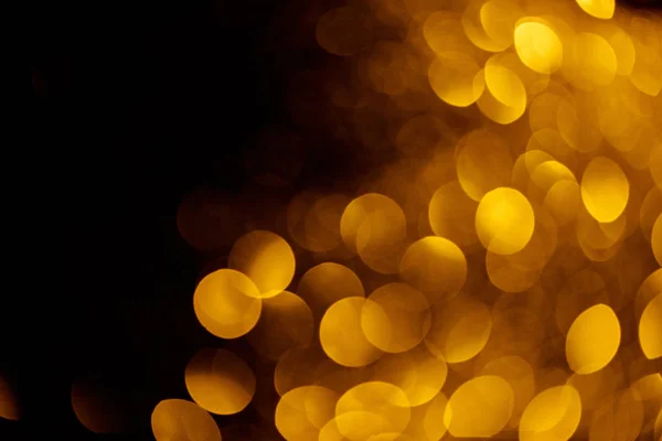 Gold bokeh on black background for holiday — Stock Photo
