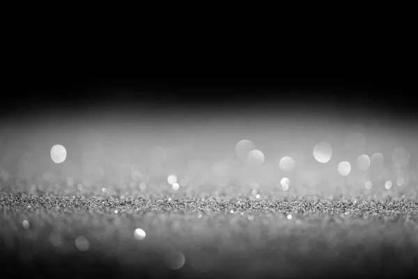 Sparking silver glitter with sparking bokeh on black background — Stock Photo