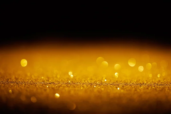 Scintillante glitter oro con bokeh su sfondo nero — Foto stock