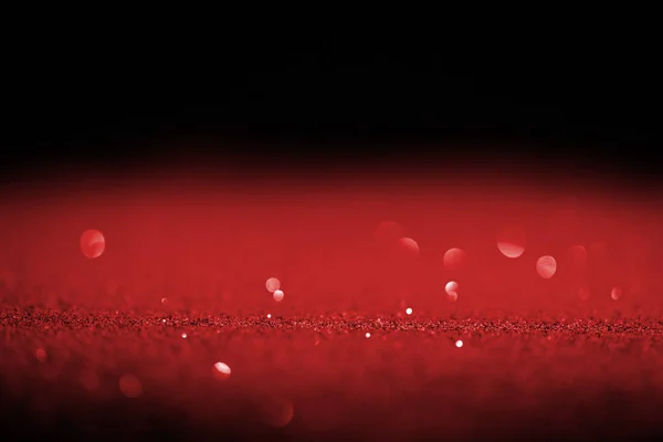 Sparking red glitter with bokeh on black background — Stock Photo
