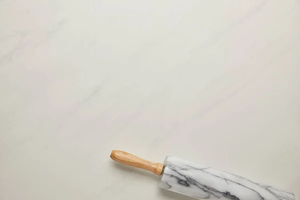 Вид сверху на скалку на поверхности белого мрамора — стоковое фото