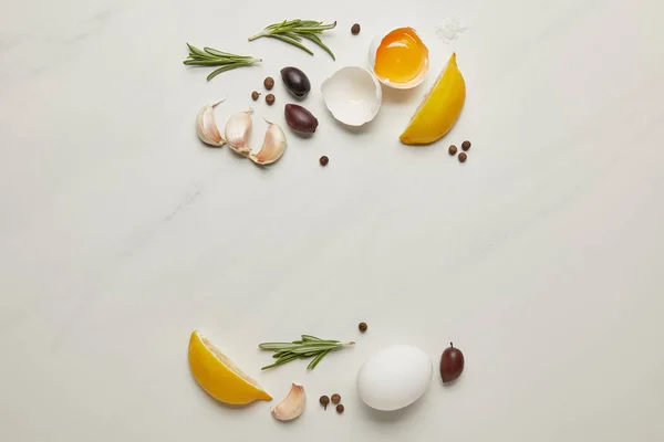 Flat lay com ovos crus de galinha, alecrim, alho e pimenta preta ingredientes para massas italianas na superfície de mármore branco — Fotografia de Stock