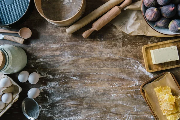 Vista superior da mesa de madeira bagunçada com farinha derramada e ingredientes de cozimento — Fotografia de Stock