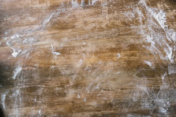 Vue du dessus de la table rustique en bois recouverte de farine — Photo de stock