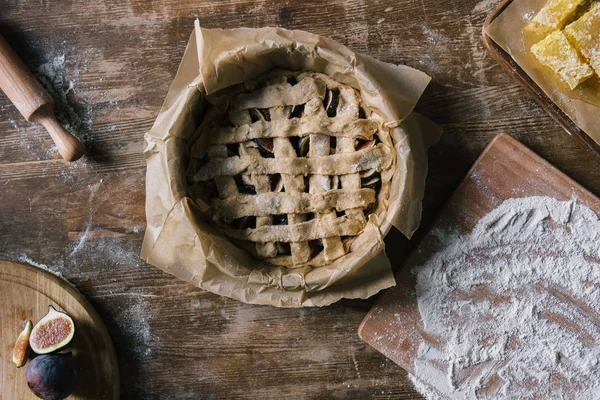 Draufsicht auf ungekochten Feigenkuchen mit Zutaten auf rustikalem Holztisch — Stockfoto