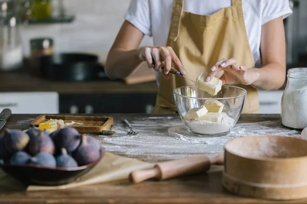 Обрезанный снимок женщины, кладущей маргарин в миску во время приготовления пирога — стоковое фото